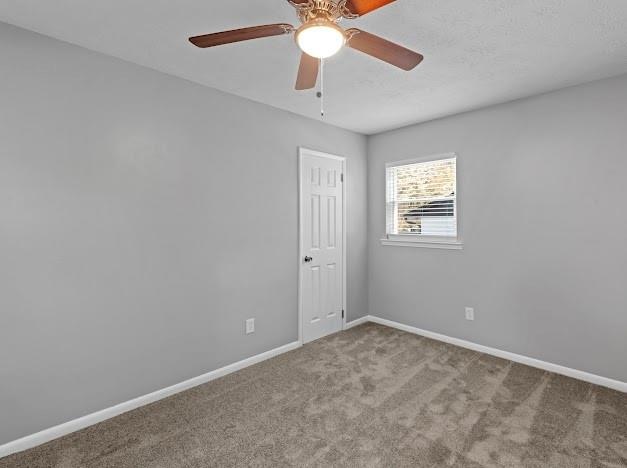 carpeted empty room featuring ceiling fan