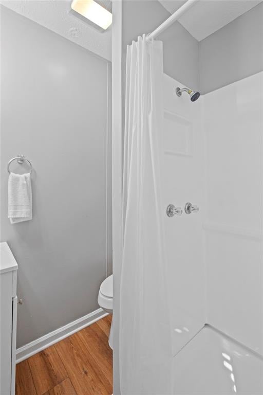 bathroom with toilet, vanity, a shower with shower curtain, and hardwood / wood-style flooring