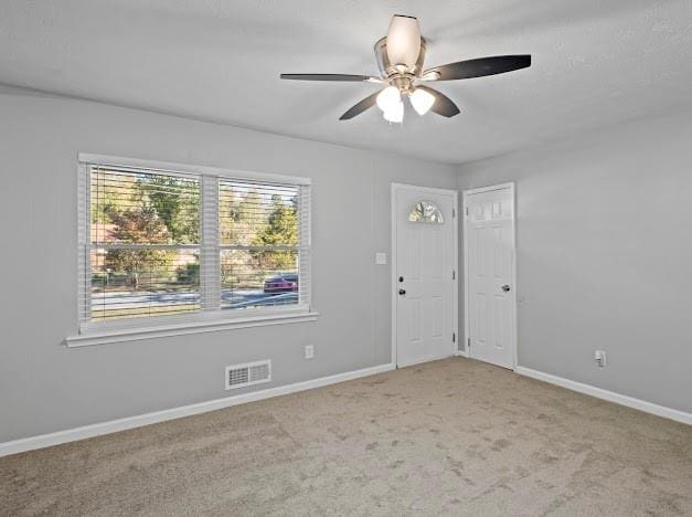 carpeted empty room featuring ceiling fan