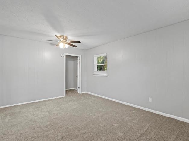 carpeted empty room featuring ceiling fan