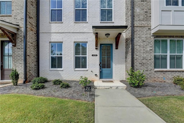 view of exterior entry featuring brick siding