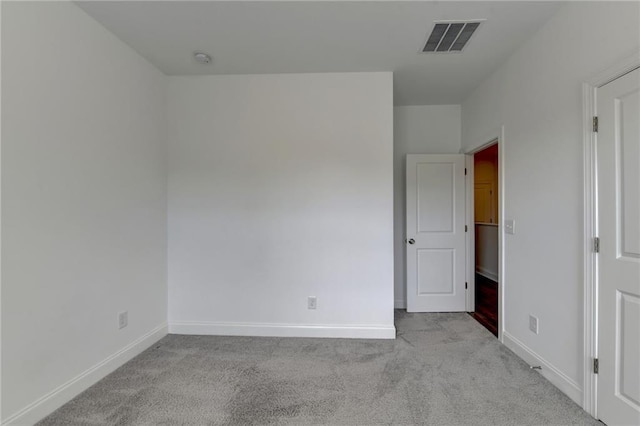 unfurnished bedroom featuring baseboards, visible vents, and light carpet