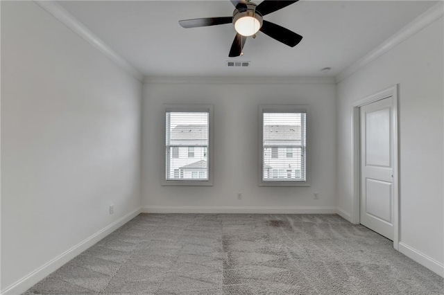 unfurnished room featuring visible vents, light colored carpet, crown molding, and baseboards