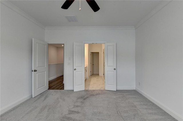 unfurnished bedroom with visible vents, baseboards, carpet flooring, and crown molding