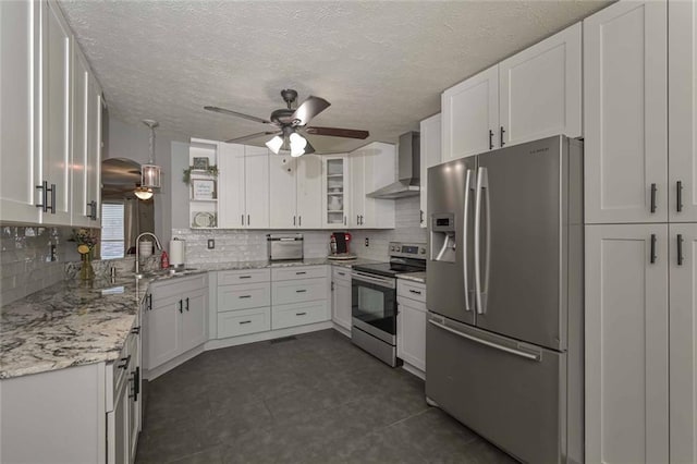 kitchen with white cabinetry, wall chimney exhaust hood, appliances with stainless steel finishes, and a sink