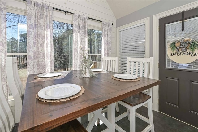 dining area featuring a healthy amount of sunlight and vaulted ceiling