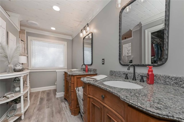 bathroom featuring ornamental molding, wooden ceiling, a walk in closet, and vanity