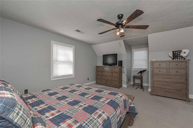 bedroom featuring a textured ceiling, lofted ceiling, light colored carpet, visible vents, and baseboards