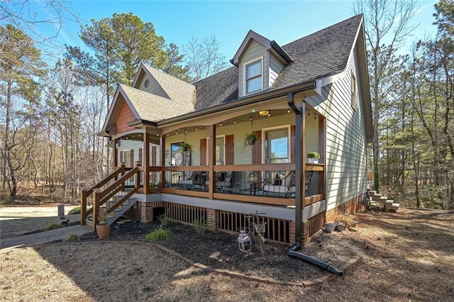 view of front facade with covered porch and roof with shingles