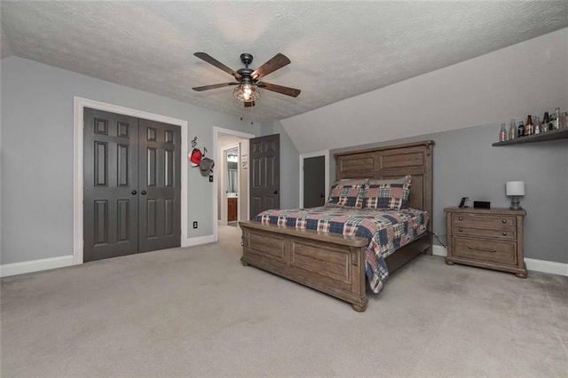 bedroom featuring a textured ceiling, light carpet, a ceiling fan, baseboards, and vaulted ceiling