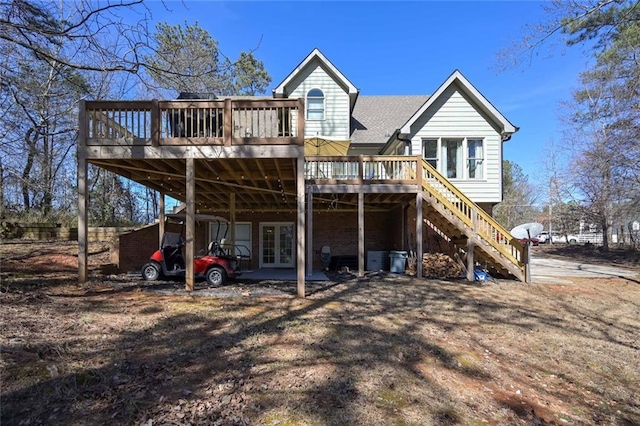 rear view of property featuring a carport, roof with shingles, a deck, and stairs