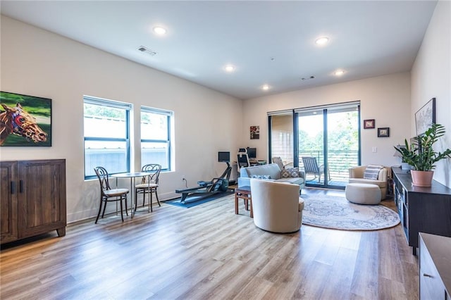 living area with visible vents, recessed lighting, light wood-style floors, and baseboards