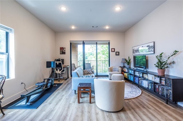 living area with recessed lighting, wood finished floors, and visible vents