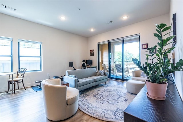 living area with visible vents, recessed lighting, and wood finished floors