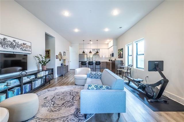 living area with recessed lighting, baseboards, visible vents, and wood finished floors