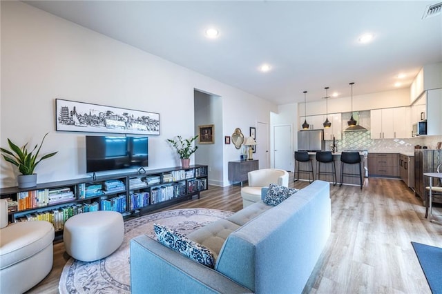 living room featuring visible vents, recessed lighting, and light wood-style flooring