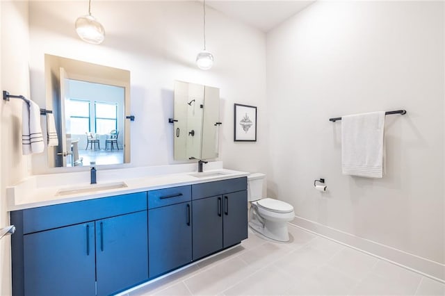 bathroom featuring a sink, a shower stall, toilet, and double vanity