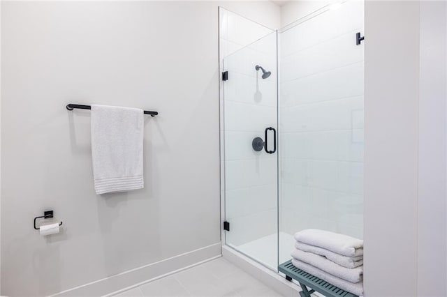 bathroom featuring baseboards, a shower stall, and tile patterned flooring
