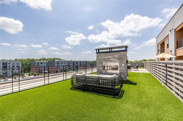 view of yard with a patio area, a stone fireplace, and fence