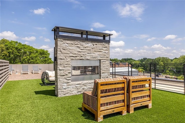 view of outbuilding with a stone fireplace and fence