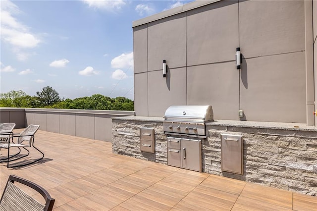 view of patio / terrace featuring exterior kitchen and a grill