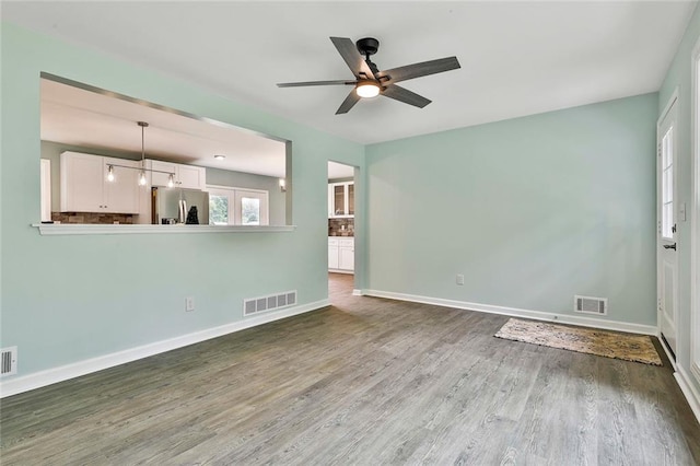 191 Pine St NE, Fairburn, GA 30213 - unfurnished living room with a ceiling fan, wood finished floors, and baseboards