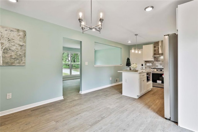 191 Pine St NE, Fairburn, GA 30213 - kitchen with a chandelier, stainless steel appliances, backsplash, white cabinets, and light wood-type flooring