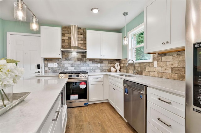191 Pine St NE, Fairburn, GA 30213 - kitchen with appliances with stainless steel finishes, wall chimney exhaust hood, light countertops, a sink, and white cabinetry