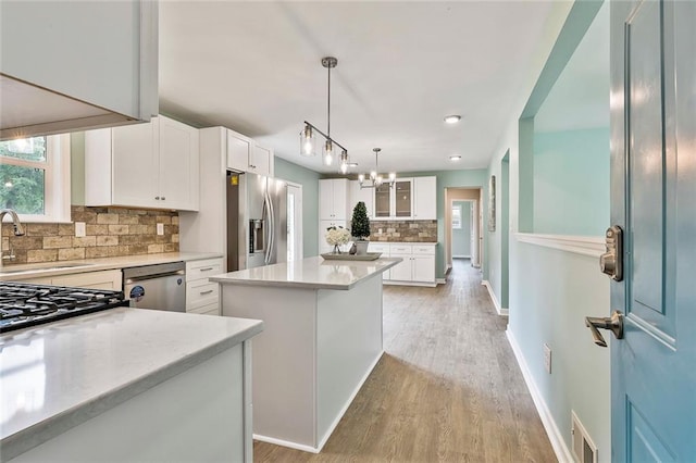 191 Pine St NE, Fairburn, GA 30213 - kitchen with a sink, stainless steel appliances, backsplash, a center island, and light wood-type flooring