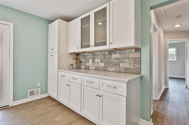 191 Pine St NE, Fairburn, GA 30213 - kitchen featuring light wood-type flooring, tasteful backsplash, light countertops, and baseboards