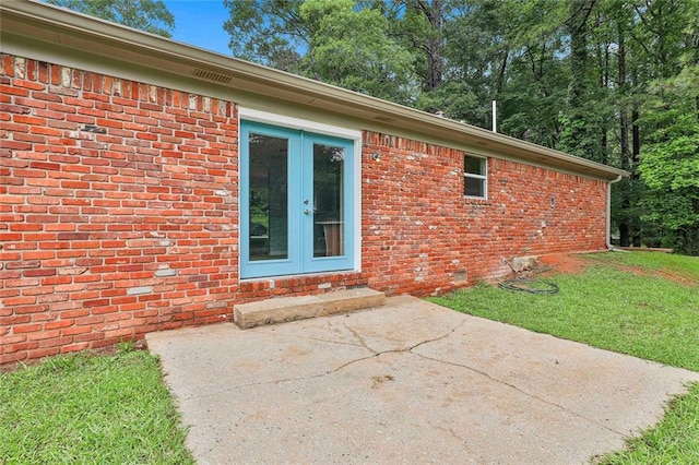 191 Pine St NE, Fairburn, GA 30213 - entrance to property featuring french doors, brick siding, a patio area, and a lawn
