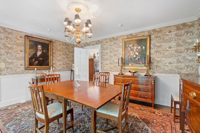 dining area featuring a chandelier, wainscoting, and ornamental molding