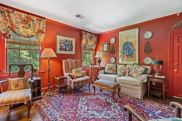 living area featuring ornamental molding and wood finished floors