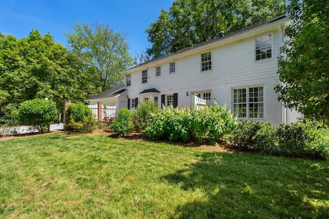 rear view of property with a lawn