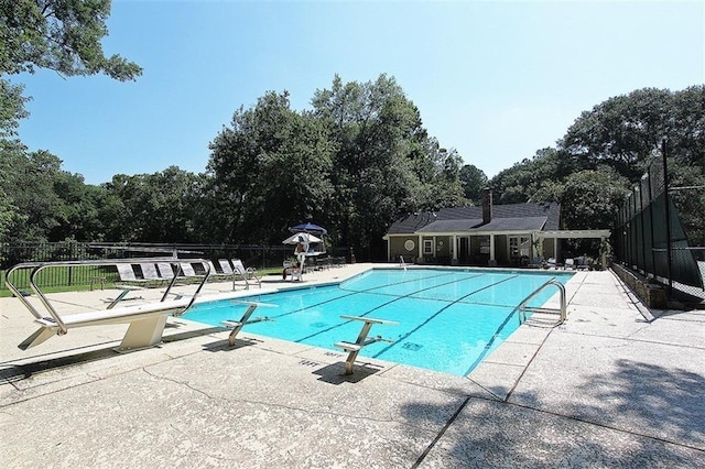 2580 Hyde Manor Dr, Atlanta, GA 30327 - community pool with a diving board, a patio area, fence, and view of scattered trees