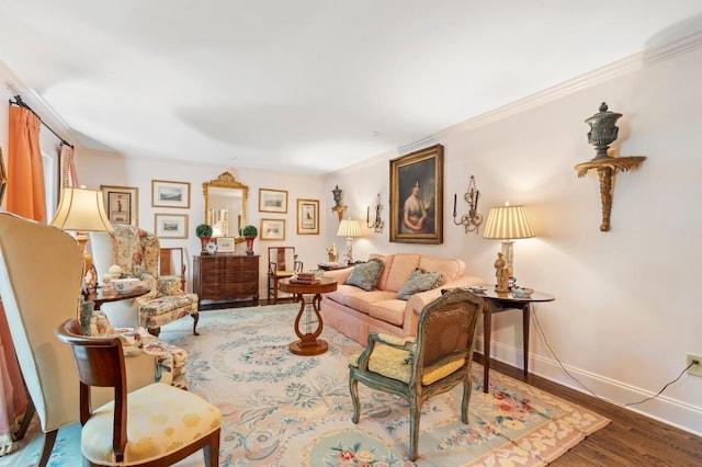 living area featuring wood finished floors, crown molding, and baseboards