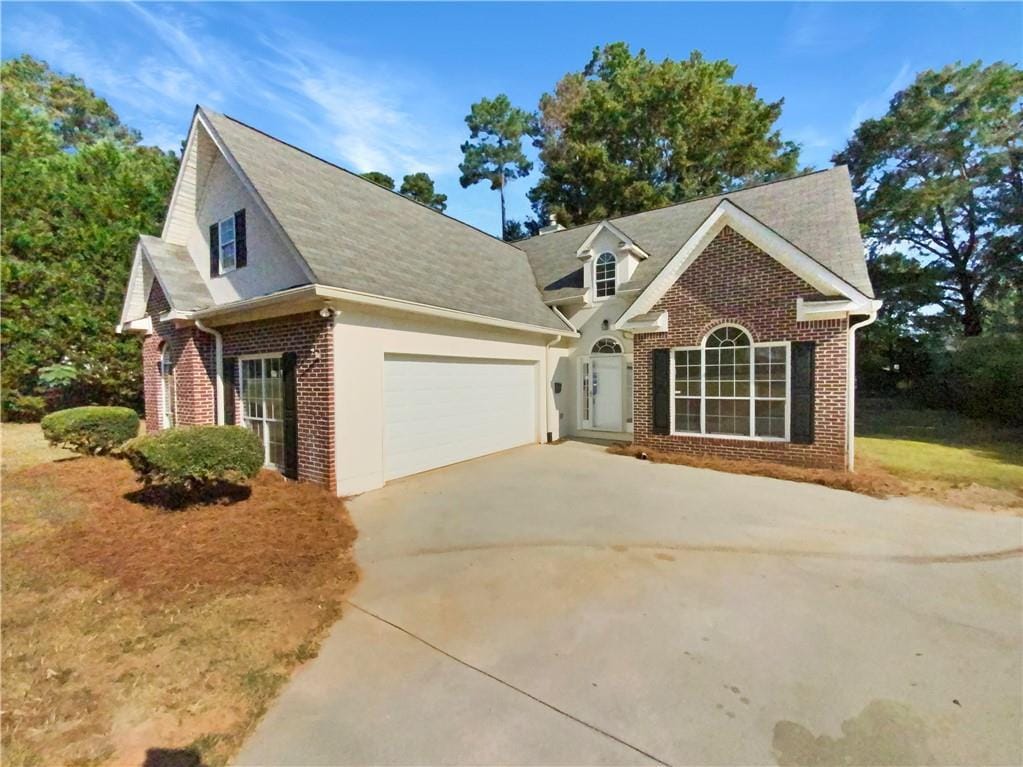 view of front of property with a garage, concrete driveway, and brick siding