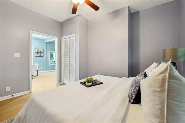 bedroom with ceiling fan, light hardwood / wood-style floors, and a closet