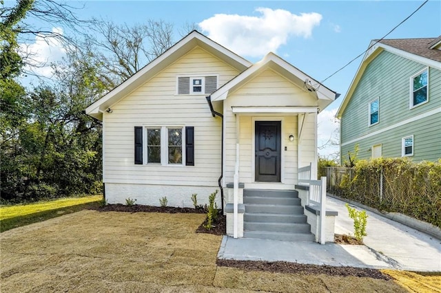 bungalow-style home with a front lawn