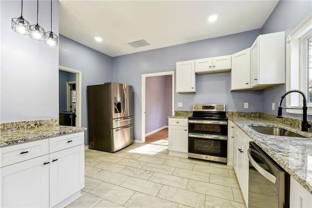 kitchen featuring white cabinets, appliances with stainless steel finishes, sink, and pendant lighting