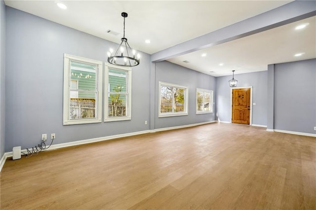 unfurnished living room with light hardwood / wood-style floors and a notable chandelier