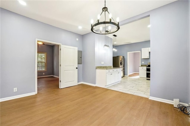 interior space with light wood-type flooring and an inviting chandelier