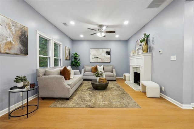 living room featuring ceiling fan and light hardwood / wood-style floors