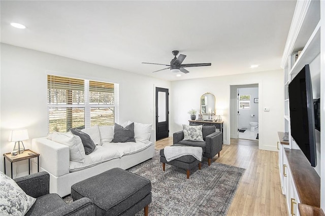 living area with baseboards, light wood-type flooring, a ceiling fan, and recessed lighting