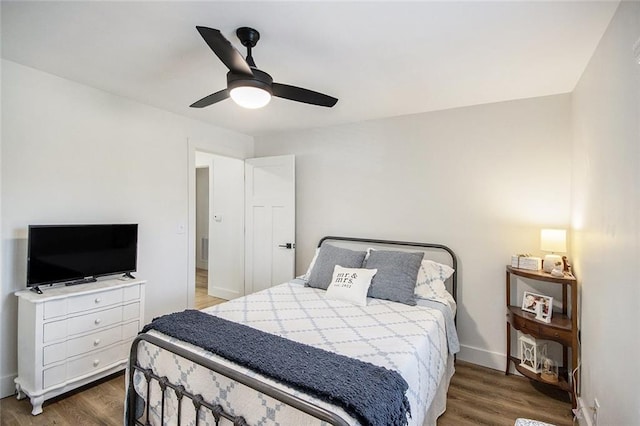 bedroom featuring a ceiling fan, baseboards, and wood finished floors