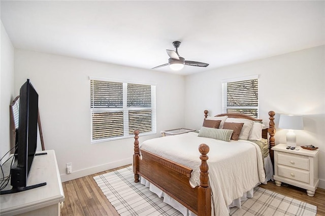 bedroom with ceiling fan, light wood-style flooring, and baseboards