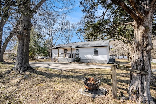 view of front of property featuring a fire pit and central AC unit