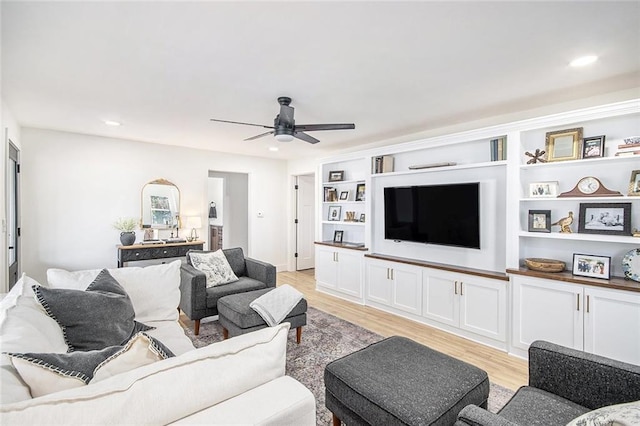 living room featuring ceiling fan, built in shelves, light wood-style flooring, and recessed lighting