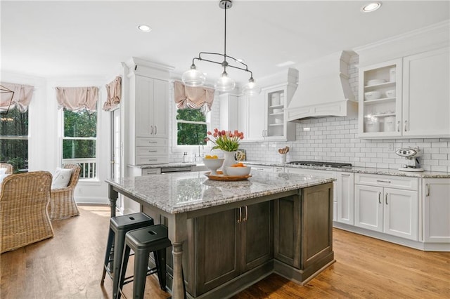 6219 Creekstone Path, Cumming, GA 30041 - kitchen with custom exhaust hood, white cabinetry, plenty of natural light, stainless steel gas cooktop, and crown molding