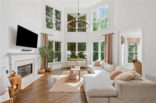 6219 Creekstone Path, Cumming, GA 30041 - living room featuring plenty of natural light, a chandelier, a high ceiling, wood finished floors, and a high end fireplace